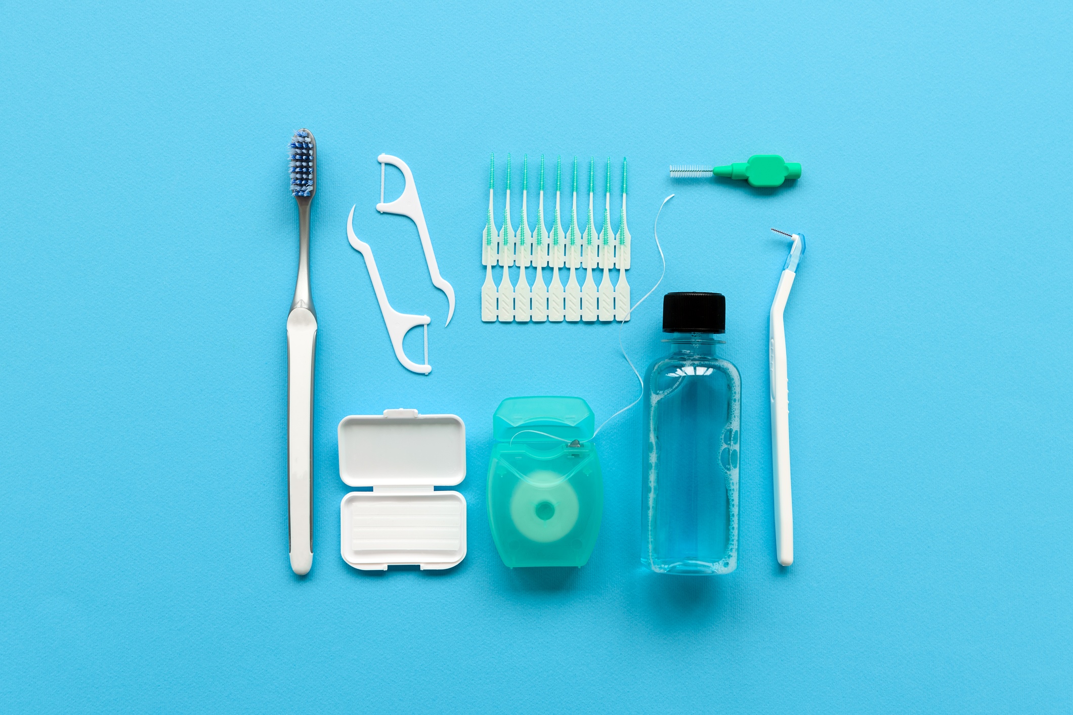 Dental hygiene tools including toothbrush, floss, interdental brushes and mouthwash.