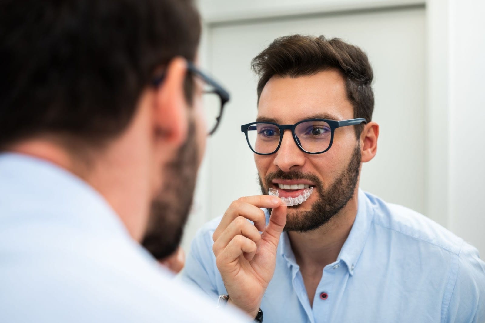 Man Inserting Invisalign Retainers
