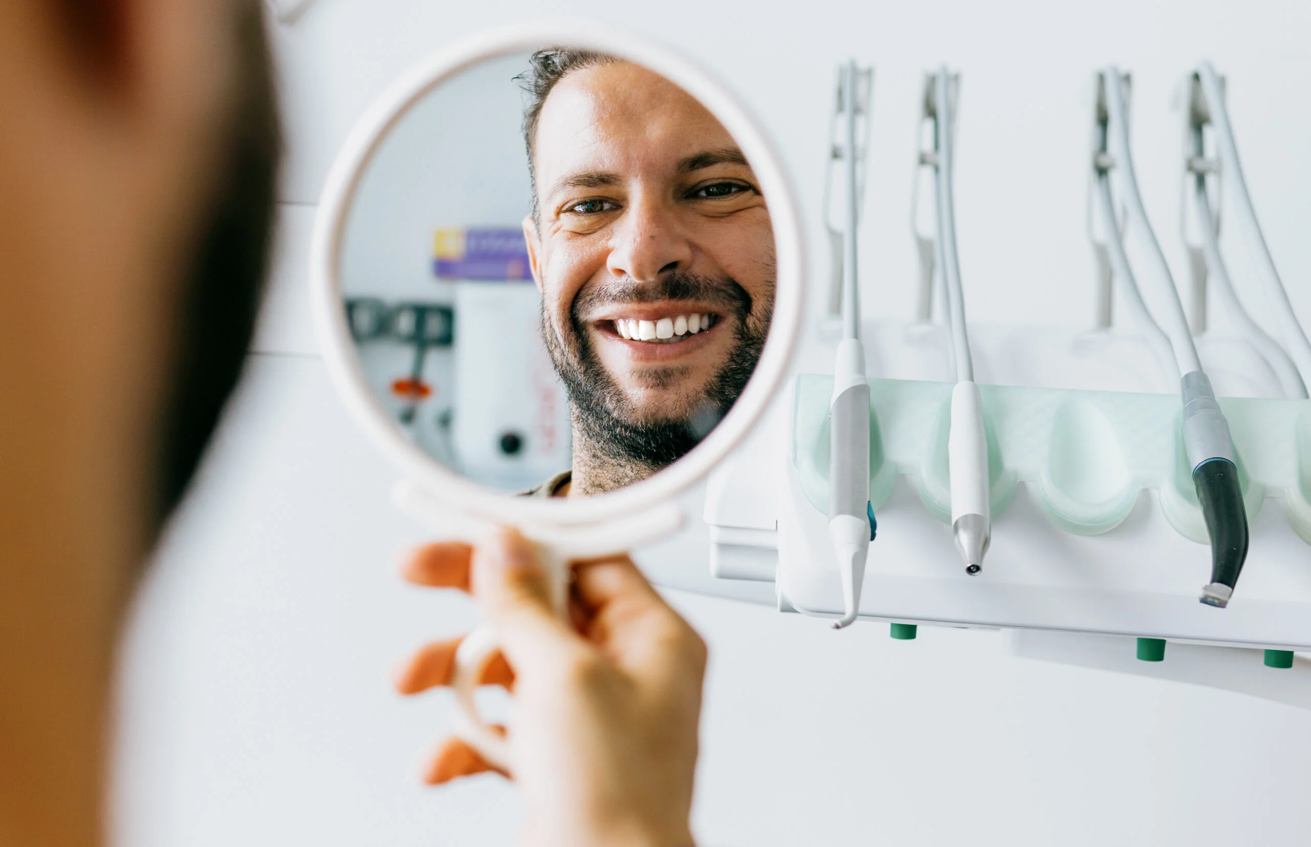 Man Smiling In Handhels Mirror