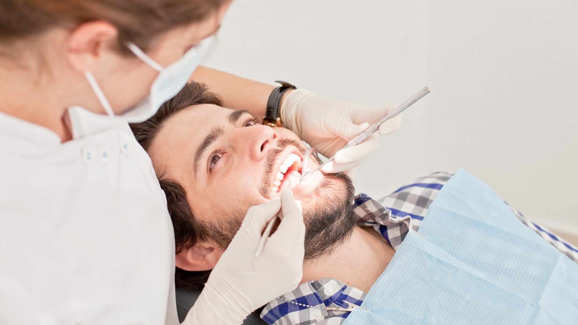 Dentist examining a patient's teeth to assess the need for a dental extraction
