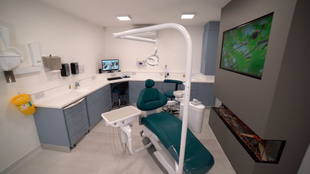 Dental practice room featuring a dental chair, a fireplace, and a TV