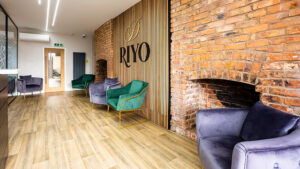 Dentist receptionist sitting area with the word "Riyo" displayed on the wall