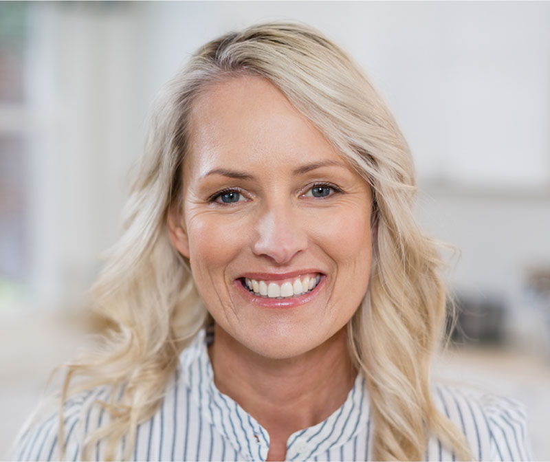 Older blonde woman smiling with white teeth
