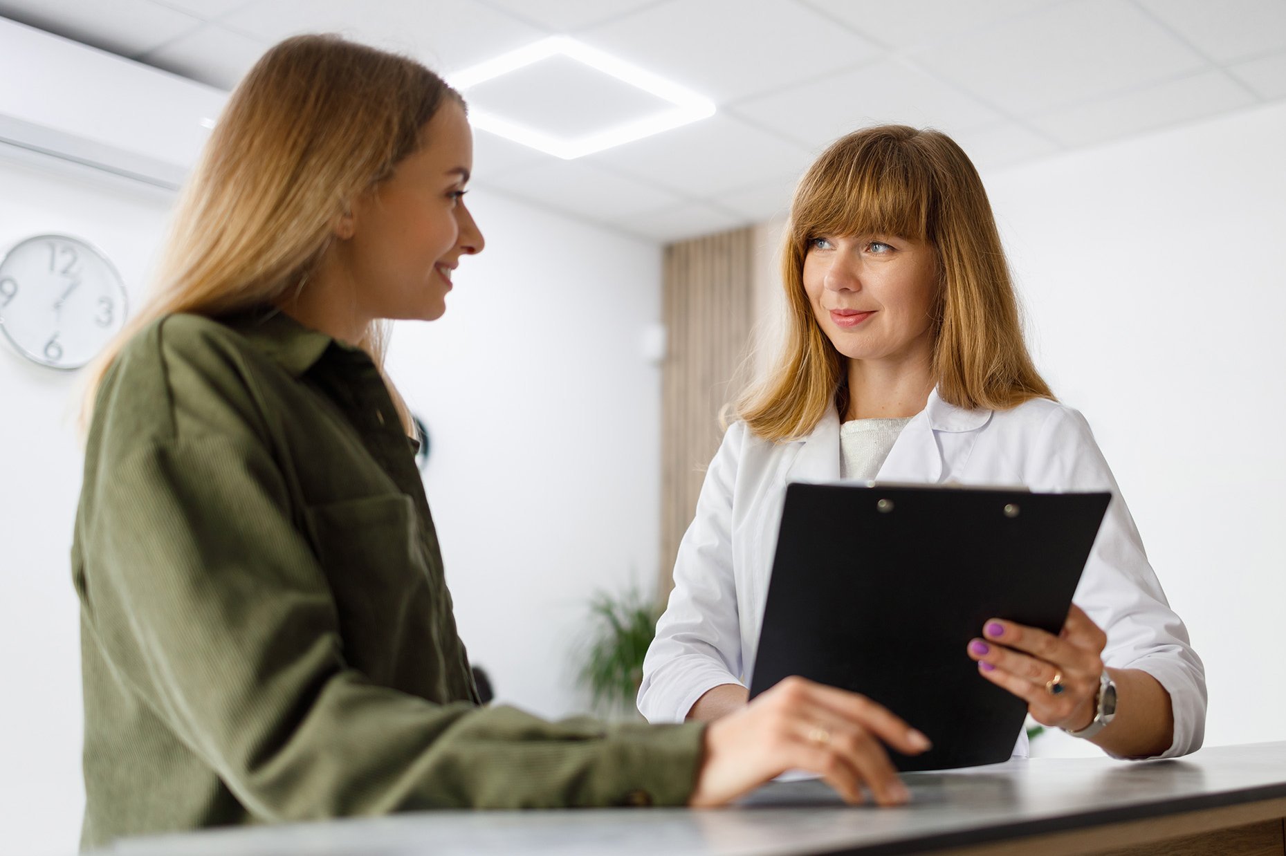 Dentist discussing treatment options with a smiling patient at a modern dental clinic.